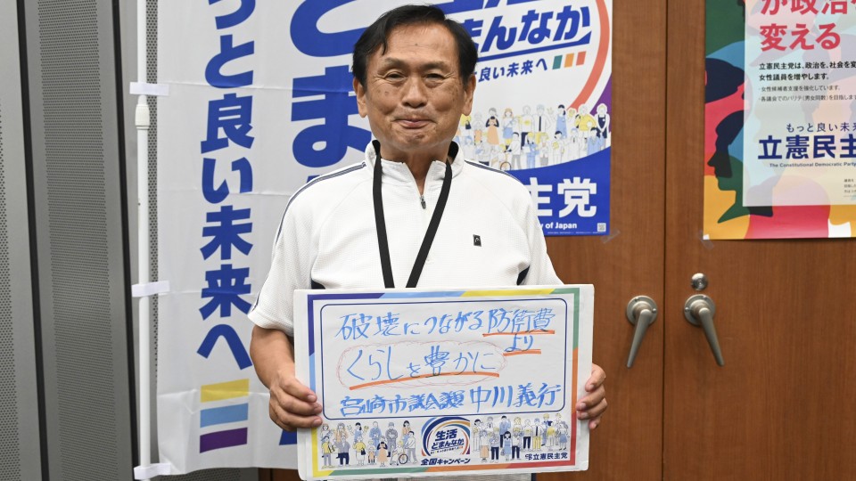 宮崎県宮崎市 中川義行市議がメッセージボードをもつ写真