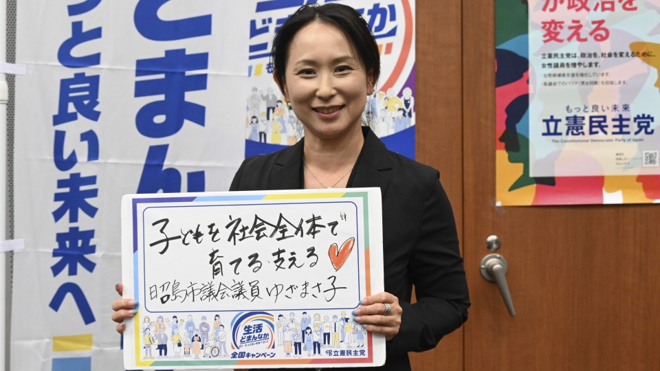 東京都昭島市 ゆざまさ子市議がメッセージボードをもつ写真