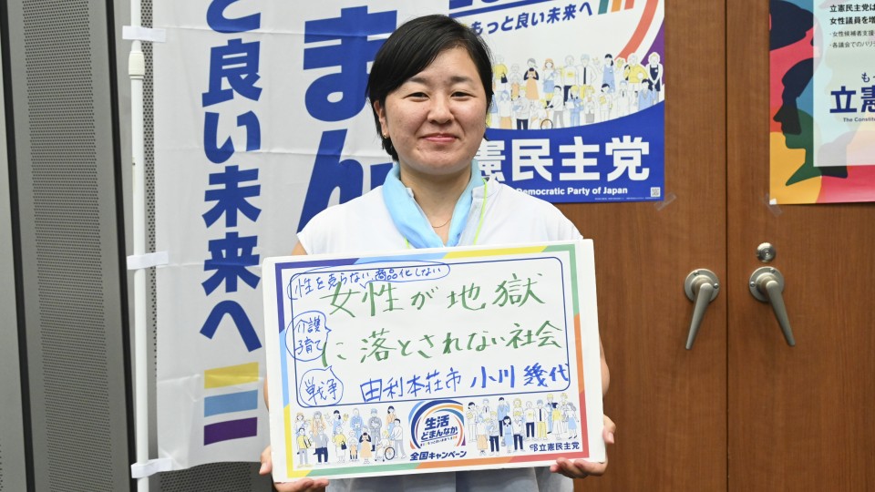 秋田・由利本荘市・小川のりよ元由利本荘市議がメッセージボードをもつ写真